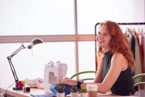 在工作室用缝纫机在时装行业工作的女学生或女企业主的微笑 — 图库照片