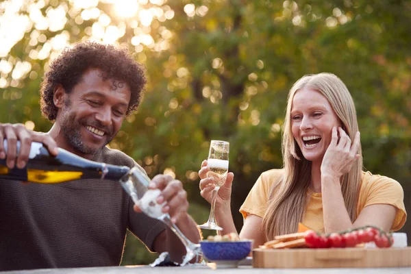 Mature Man Pouring Champagne Couple Celebrate Sitting Table Garden Snacks — Stock Photo, Image