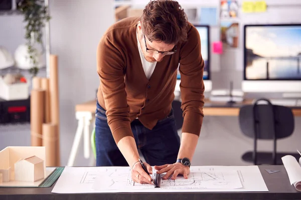 オフィスのデスクに立つ男性建築家定規で計画やブループリントを変更する — ストック写真