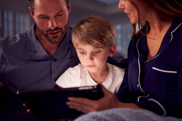 Niño Con Padres Pijama Sentado Sofá Viendo Juntos Tableta Digital —  Fotos de Stock