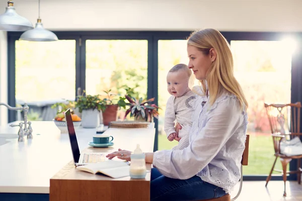 Arbetande Mor Använder Laptop Hemma Medan Håller Leende Son Knä — Stockfoto