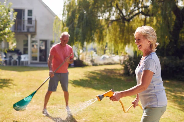 Pensionerat Par Jobbet Vattning Växter Med Slang Och Städning Trädgård — Stockfoto