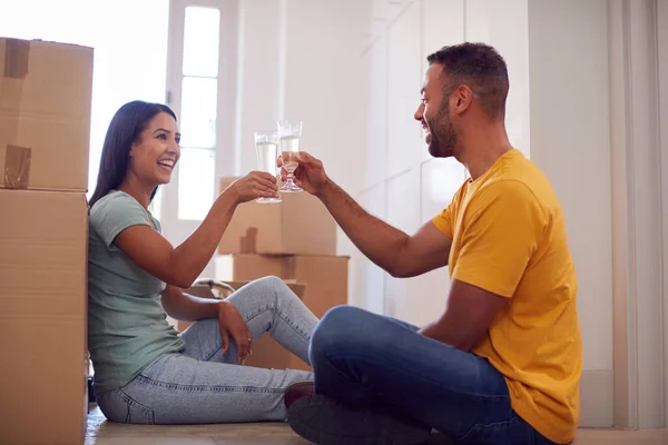 Casal Comemorando Com Champanhe Sentado Chão Nova Casa Dia Mudança — Fotografia de Stock