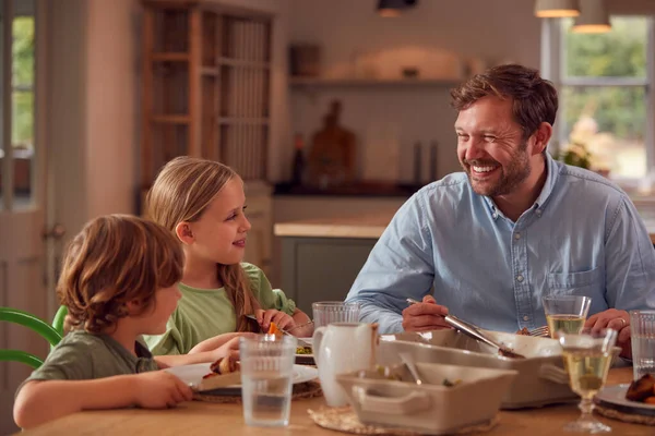 Padre Hijos Sentados Alrededor Mesa Casa Disfrutando Comida Juntos —  Fotos de Stock