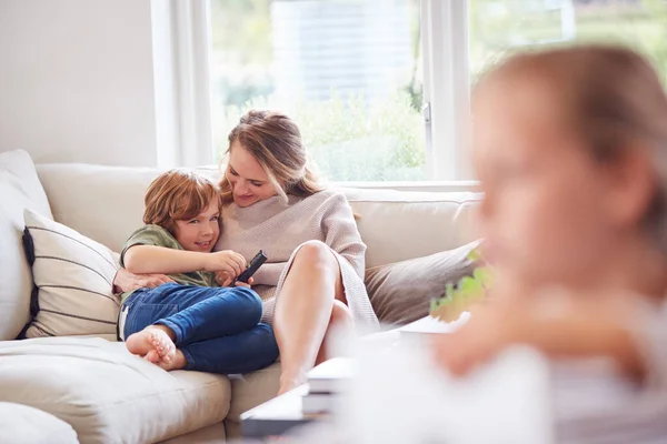 Mother Relaxing Children Sofa Home Watching Together — Stock Photo, Image