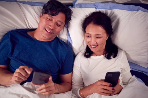 Starší Asijské Pár Nošení Pyžama Ležící Posteli Při Pohledu Mobilní — Stock fotografie