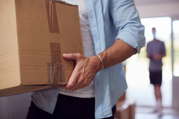 引っ越しの日に新しい家の玄関を通って箱を運ぶ男性カップルの閉鎖 — ストック写真