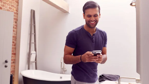 Muž Nosí Pyžama Doma Kontrola Mobilního Telefonu Moderní Koupelně — Stock fotografie