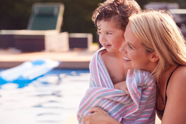 暑假时 母亲在户外游泳池边的毛巾里给儿子包扎 — 图库照片