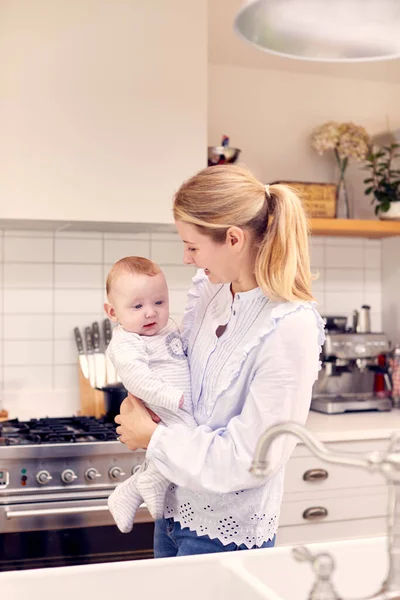 Madre Casa Cocina Sosteniendo Sonriente Bebé Hijo —  Fotos de Stock