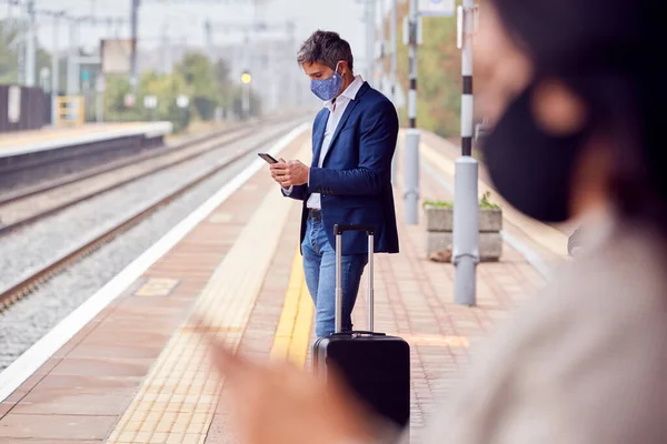 Dojeżdżający Pracy Platformie Kolejowej Telefonów Komórkowych Noszących Maski Twarzy Śoi — Zdjęcie stockowe