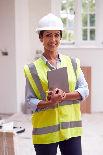 女性建筑测量师头戴硬帽 带数码记事板看新物业的肖像 — 图库照片