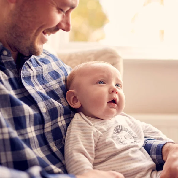 Father Cuddling Baby Son Sitting Lap Lounge Chair Home Together — 스톡 사진