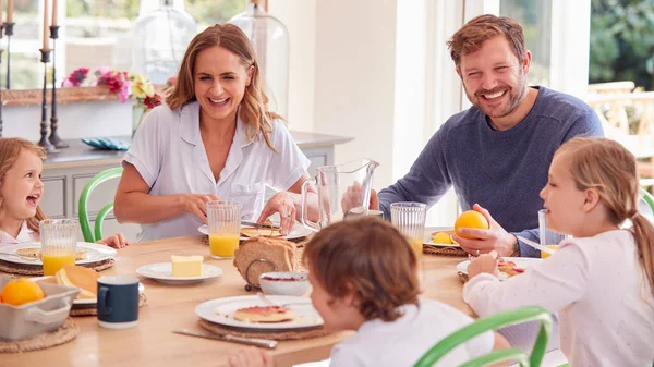 Familia Vistiendo Pijamas Sentados Alrededor Mesa Disfrutando Del Desayuno Panqueques —  Fotos de Stock