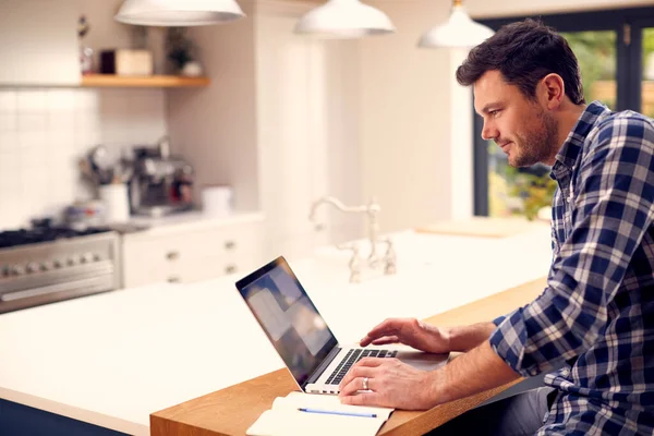 Людина Працює Дому Використовуючи Ноутбук Кухонній Лічильнику — стокове фото