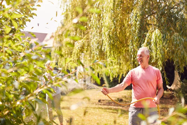 Couple Retraité Travail Arrosant Des Usines Avec Tuyau Rangeant Jardin — Photo