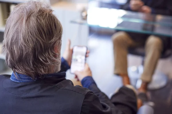 Widok Tyłu Starszego Mężczyzny Czekającego Strzyżenie Salonie Fryzjerskim Patrzącego Telefon — Zdjęcie stockowe