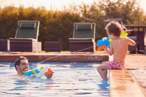 Vater Und Sohn Spritzen Sich Mit Wasserpistolen Schwimmbad Sommerurlaub — Stockfoto