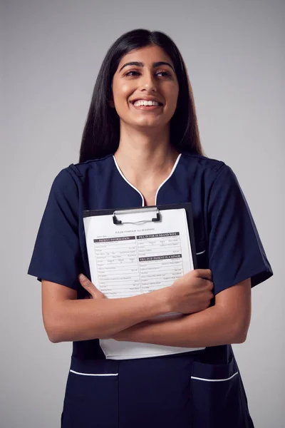 Studioporträt Einer Lächelnden Krankenschwester Mit Klemmbrett Uniform Vor Schlichtem Hintergrund — Stockfoto