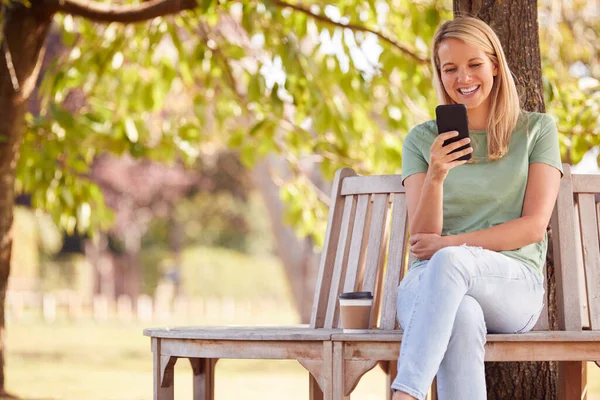 Женщина Сидящая Скамейке Деревом Летнем Парке Помощью Мобильного Телефона — стоковое фото