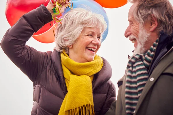 Liefdevolle Senior Paar Holding Ballonnen Genieten Van Herfst Winter Walk — Stockfoto