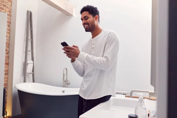 Homem Vestindo Pijama Casa Verificando Telefone Móvel Banheiro Moderno — Fotografia de Stock