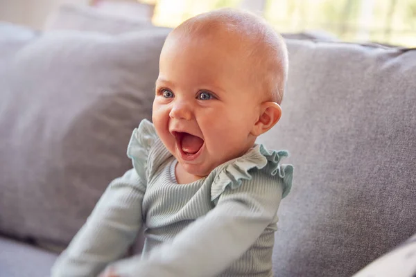 Niedliches Baby Mädchen Sitzt Auf Sofa Und Lacht Und Lächelt — Stockfoto