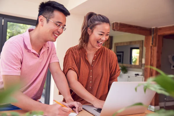 Pareja Sonriente Sentada Mesa Casa Revisando Las Finanzas Nacionales Usando — Foto de Stock