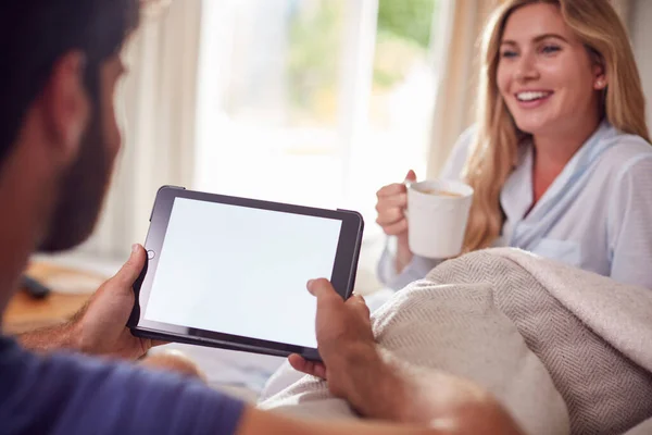 Pareja Usando Pijamas Salón Casa Charlando Usando Tableta Digital —  Fotos de Stock