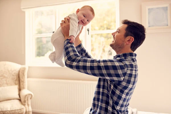 Liefdevolle Vader Tillen Baby Zoon Lucht Als Spel Spelen Thuis — Stockfoto