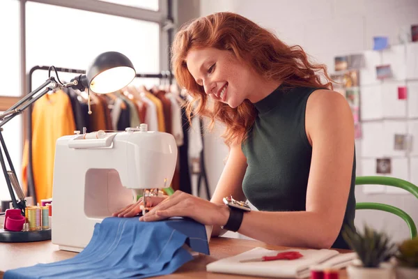 在工作室用缝纫机在时装行业工作的女学生或女企业主的微笑 — 图库照片