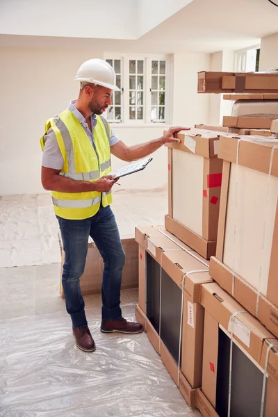 Bauunternehmer Mit Harter Mütze Und Klemmbrett Überprüft Lieferung Neuer Kücheneinheiten — Stockfoto