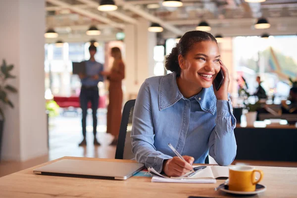 Jonge Zakenvrouw Zit Aan Balie Aan Telefoon Moderne Open Kantoorruimte — Stockfoto