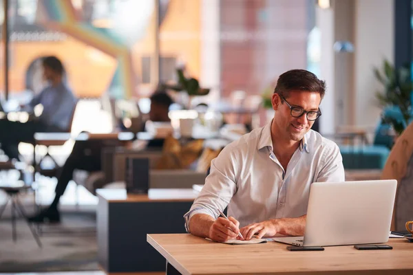 Businessman Sitting Desk Writing Notebook Modern Open Plan Office — Stock Photo, Image