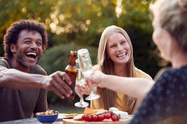Grupo Amigos Comemorando Com Cerveja Champanhe Enquanto Sentam Mesa Jardim — Fotografia de Stock