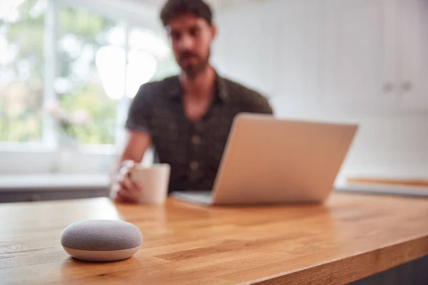 Man Kitchen Using Digital Smart Speaker Whilst Working Home Laptop — Stock Photo, Image