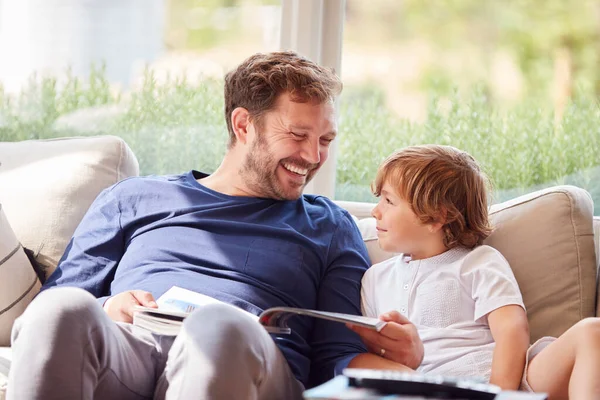 Padre Figlio Rilassano Sul Divano Casa Leggere Libro Insieme — Foto Stock