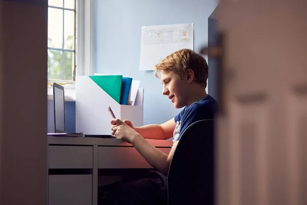 Junge Sitzt Schreibtisch Hause Schule Texten Auf Dem Handy Und — Stockfoto