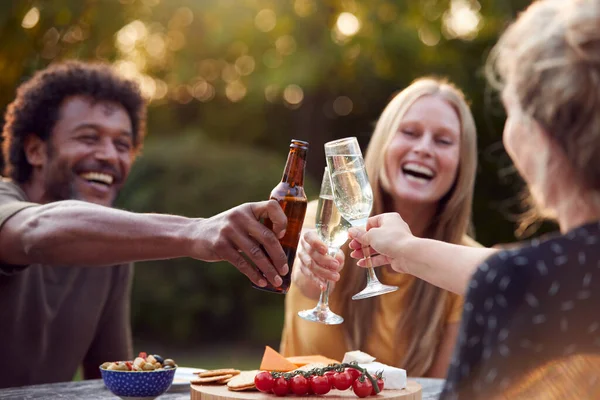 Groupe Amis Célébrant Avec Bière Champagne Comme Ils Assoient Table — Photo