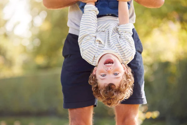 Pai Com Filho Divertindo Parque Segurando Cabeça Para Baixo Contra — Fotografia de Stock