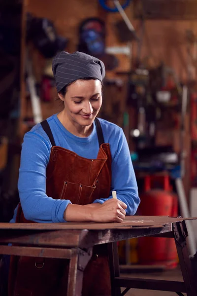 ヘッドスカーフを身に着けている女性の鍛冶屋は フォージでデザインに取り組む — ストック写真