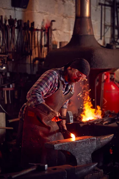 Mies Blacksmith Vasarointi Metallityöt Alasti Kanssa Blazing Forge Taustalla — kuvapankkivalokuva