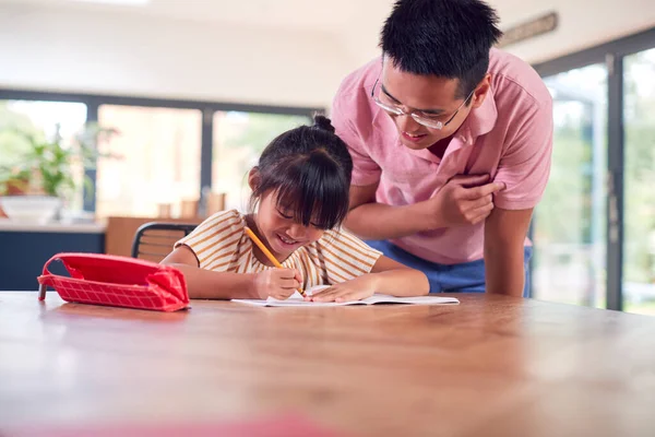 Asian Father Helping Home Schooling Daughter Working Table Kitchen Writing — Stock Photo, Image