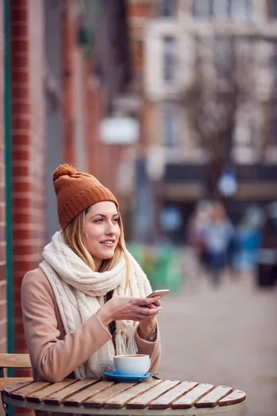 Kvinnliga Kund Skicka Textmeddelande Sitter Utanför Coffee Shop Upptagen City — Stockfoto