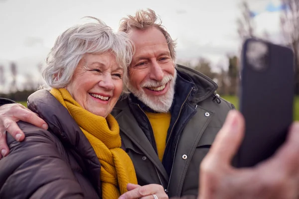 Αγαπώντας Senior Ζευγάρι Posing Για Selfie Στο Κινητό Τηλέφωνο Φθινόπωρο — Φωτογραφία Αρχείου