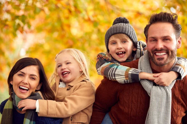 Retrato Família Com Pais Dando Crianças Piggybacks Contra Folhas Outono — Fotografia de Stock