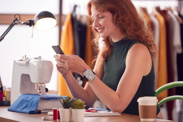 Propietaria Femenina Negocios Moda Usando Teléfono Móvil Máquina Coser Estudio —  Fotos de Stock