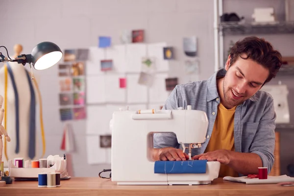 在工作室用缝纫机在时装行业工作的男性学生或企业主的微笑 — 图库照片