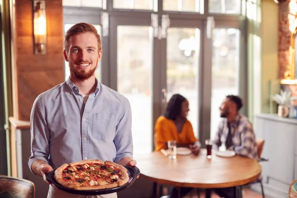 Retrato Garçom Restaurante Servindo Pizza Para Casal Mesa — Fotografia de Stock