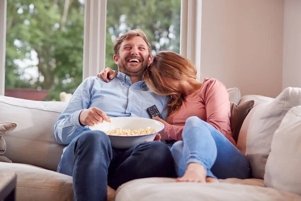 Para Randce Siedzi Kanapie Domu Śmiejąc Się Oglądając Telewizję Popcornem — Zdjęcie stockowe
